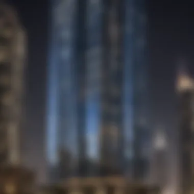 Night view of the Reflection Tower illuminated, blending with Dubai's skyline.